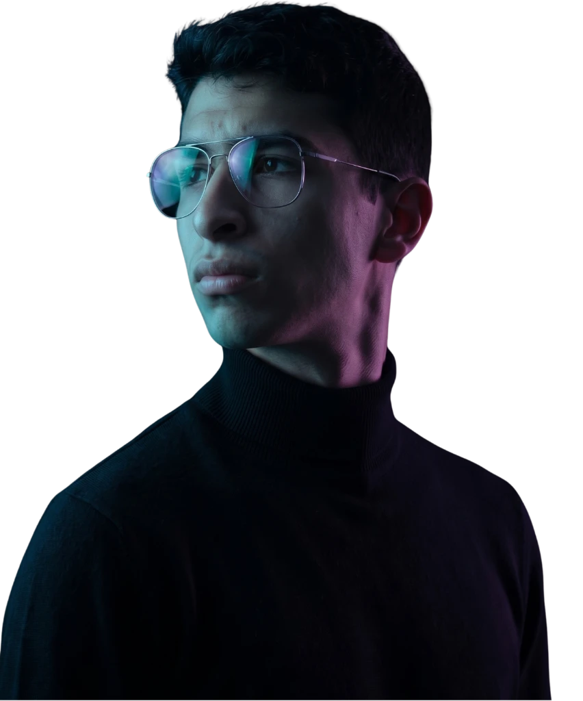 Retrato de un joven con gafas y cuello alto negro, iluminado con luces cian y violeta